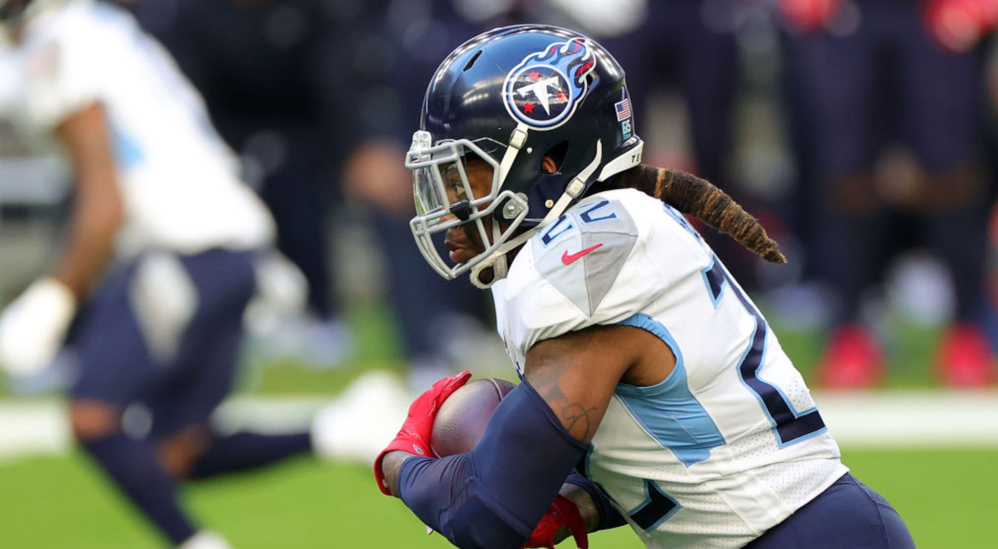 Ravens running back Derrick Henry running with the football, with his hair visible outside of his helmet