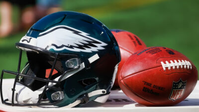 Eagles helmet next to two footballs