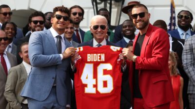 Travis Kelce, Patrick Mahomes, and Joe Biden posing with jersey