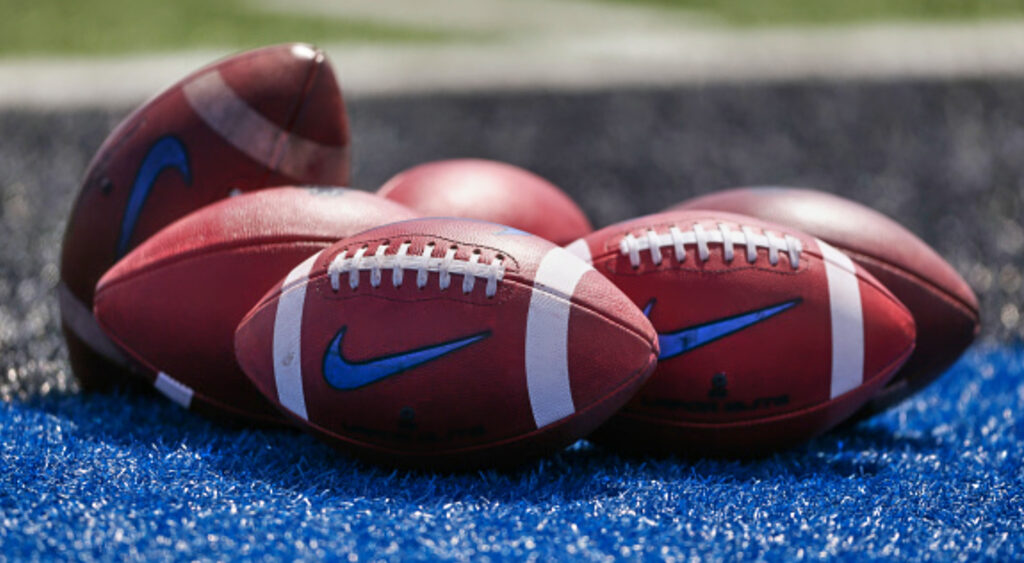 Footballs sitting on turf