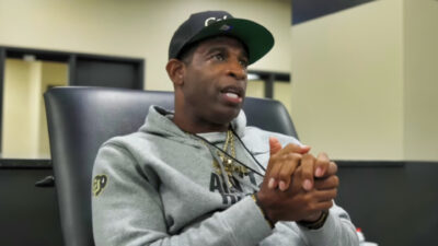 Deion Sanders holding his hands together