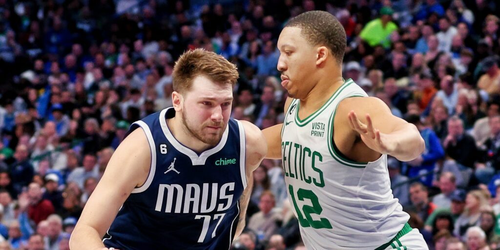 Luka Doncic of Dallas Mavericks driving to basket against Grant Williams of Boston Celtics.