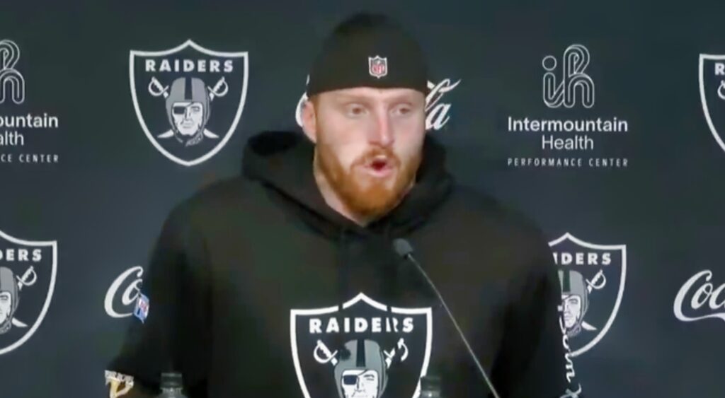 Maxx Crosby in Raiders hoodie speaking to reporters