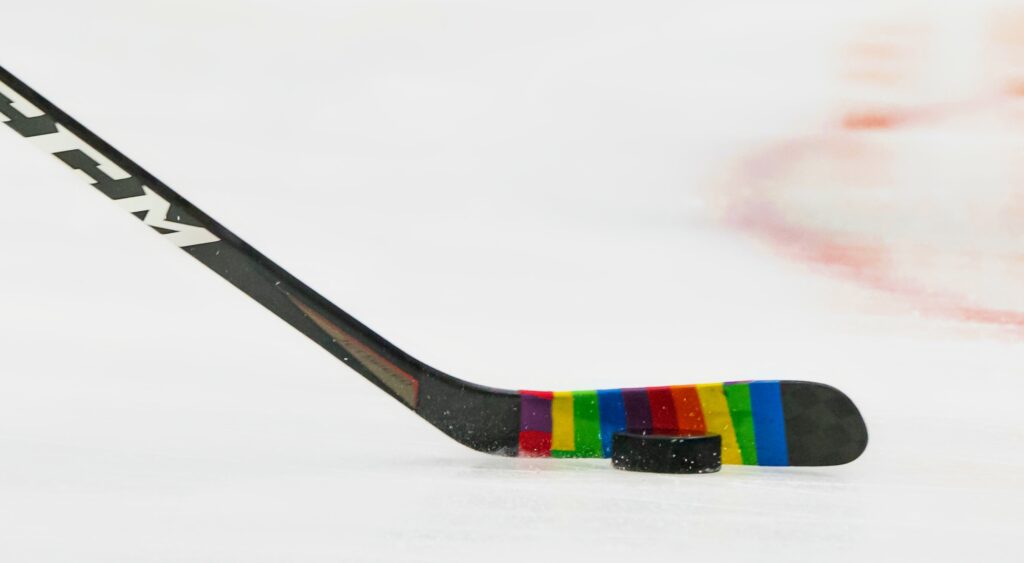 Vancouver Canucks' hockey stick rainbow tape shown on ice.