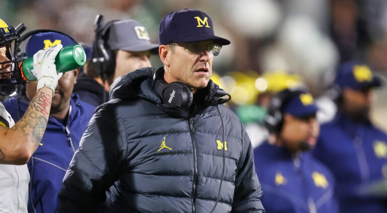 Jim Harbaugh standing in front of Michigan players