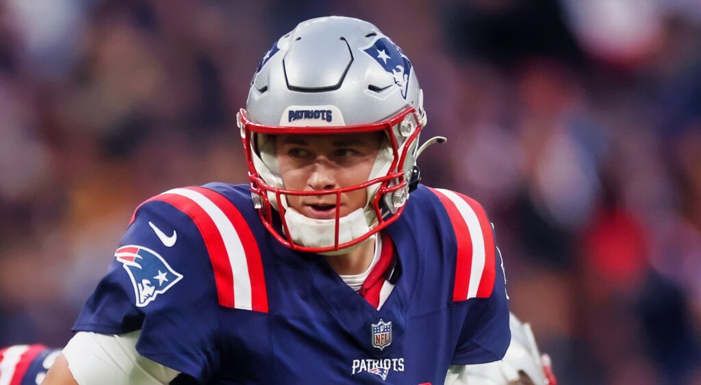 Mac Jones of New England Patriots looking to hand ball off.