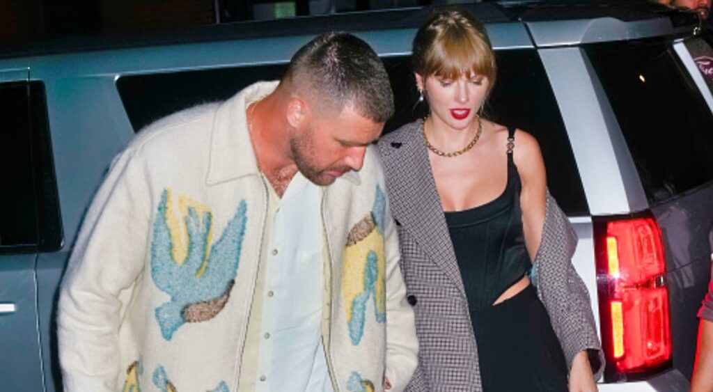 Travis Kelce walking next to Taylor Swift