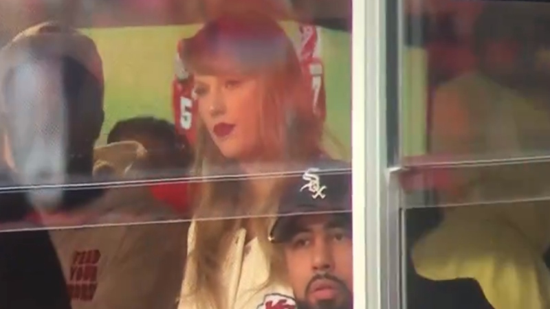 Taylor Swift looking on from suite in Kansas City Chiefs game.