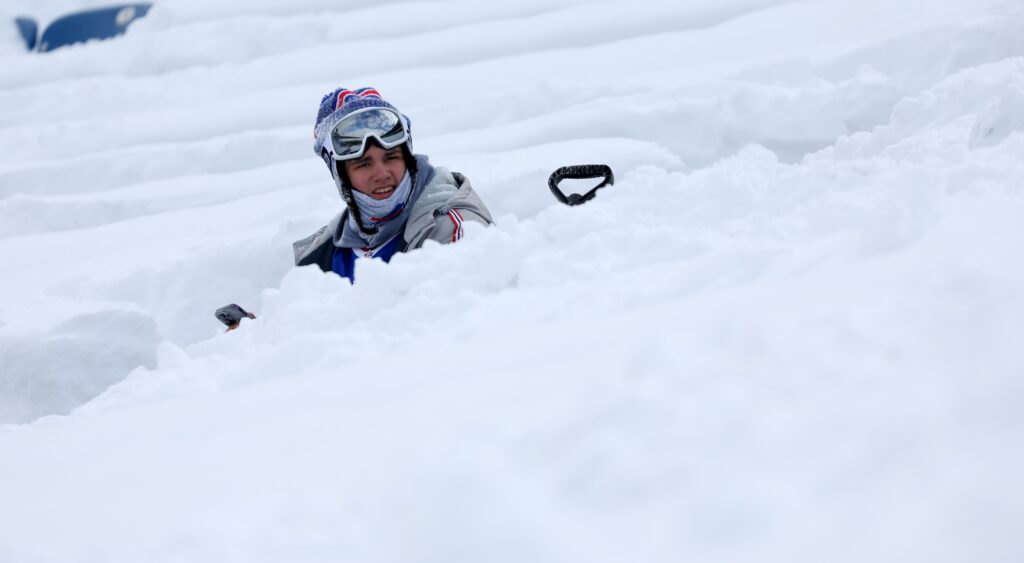 Bills fan seated in snow at Highmark Stadium.