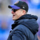 Jim Harbaugh wearing cap and sunglasses