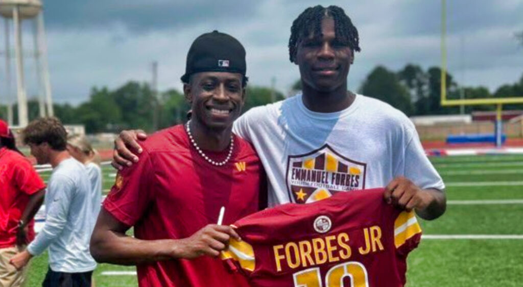 Emmanuel Forbes holding his jersey up with a fan