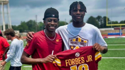 Emmanuel Forbes holding his jersey up with a fan