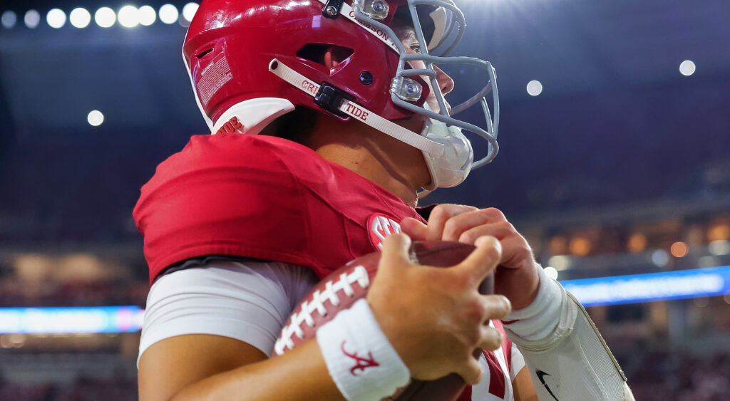 Tyler Buchner holding a football