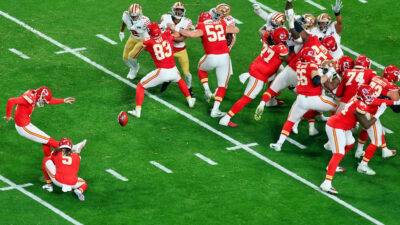 Harrison Butker kicking a football