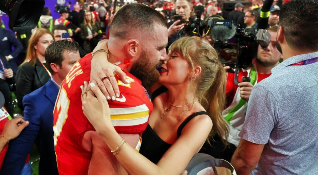 Travis Kelce and Taylor Swift embracing after game.