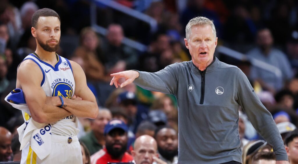 Stephen Curry (left) and Steve Kerr (right) look on.
