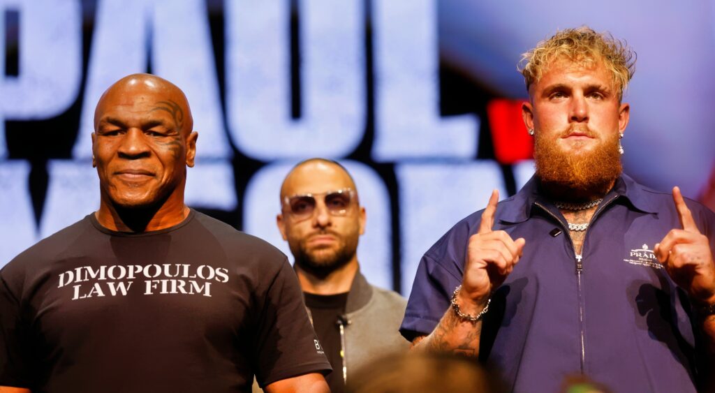 Mike Tyson (left) and Jake Paul (right) looking on.