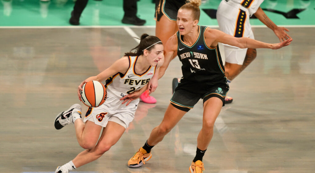 Indiana Fever Guard Caitlin Clark driving against opponent