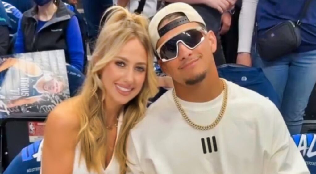 Patrick Mahomes and Brittany Mahomes posing at NBA game.