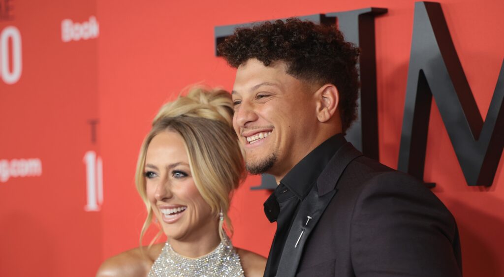 Brittany Mahomes and Patrick Mahomes smiling at event.