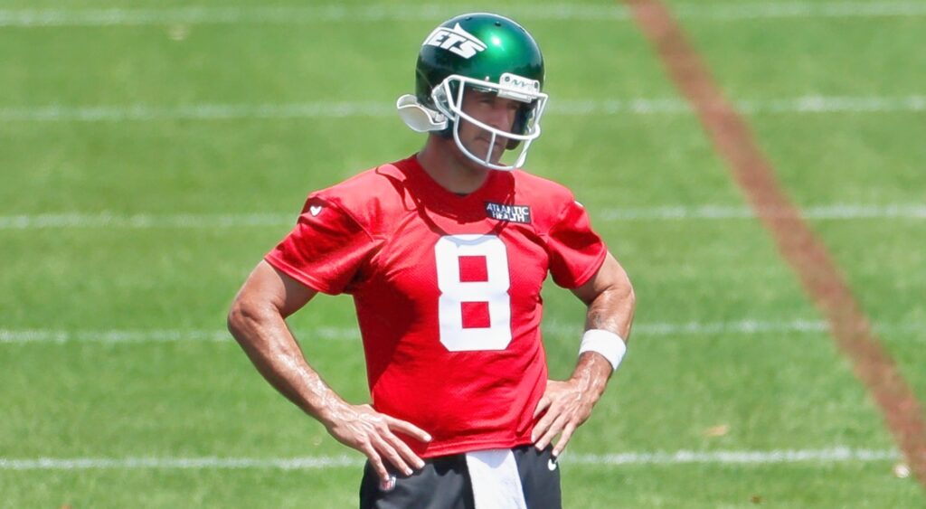 Aaron Rodgers looks on during practice with his hands on his hips.