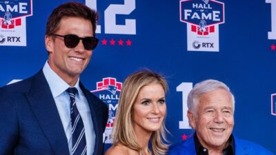Tom Brady poses with CEO of the New England Patriots Robert Kraft (R) and his wife Dana Blumberg