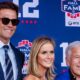 Tom Brady poses with CEO of the New England Patriots Robert Kraft (R) and his wife Dana Blumberg