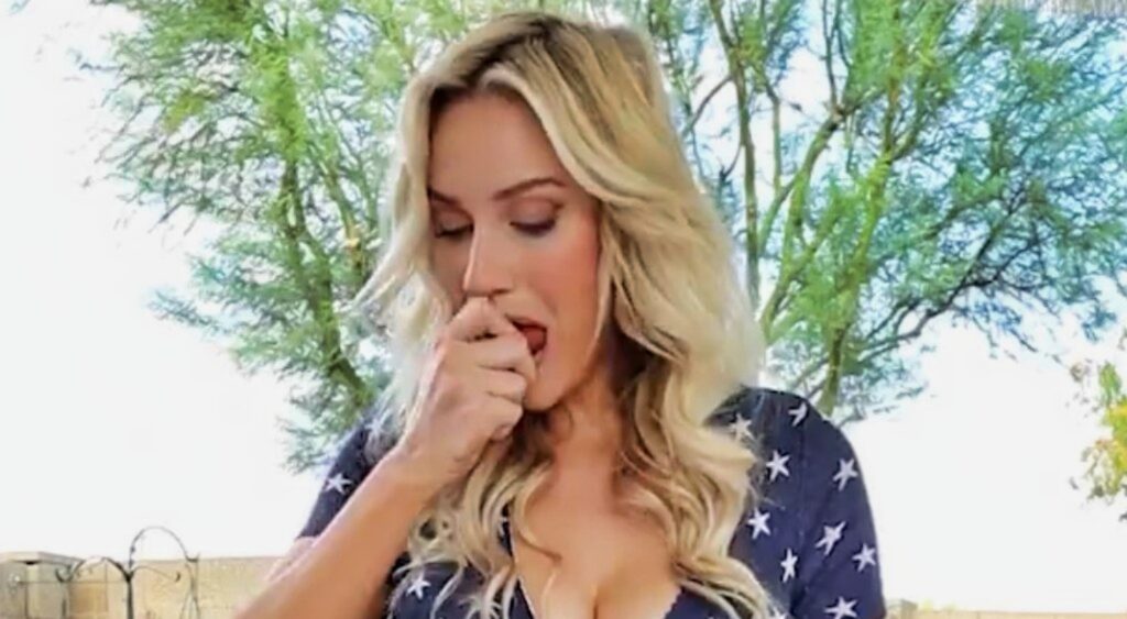 Paige Spiranac eating a hot dog.