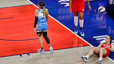 Caitlin Clark lying on the floor after foul by Chennedy Carter