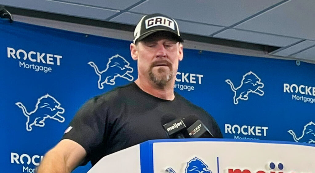 Dan Campbell behind podium during press conference.