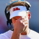 Lane Kiffin with a hand over his face