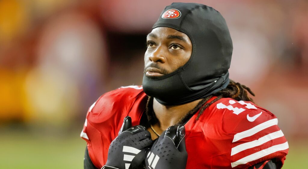 Brandon Aiyuk looks on with his helmet off.