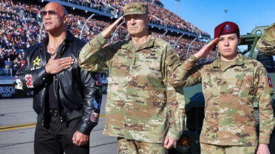 The Rock standing next to soldiers
