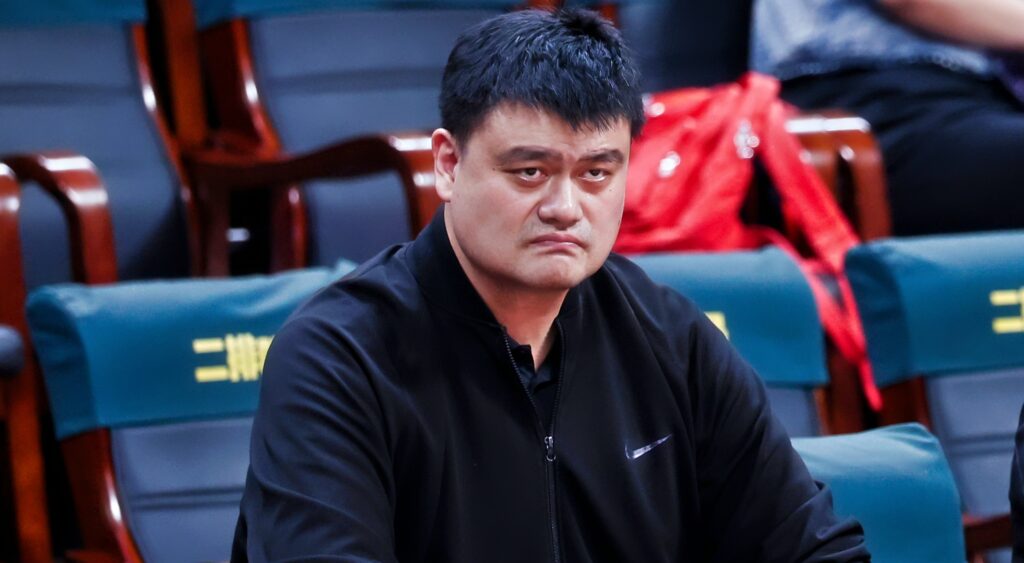 Yao Ming looks on while watching a basketball game.