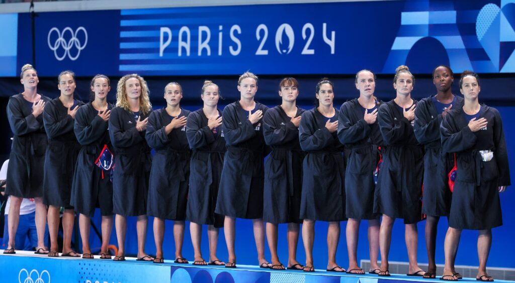 Maggie Steffens and the US Polo team stand for the anthem at the Olympics.