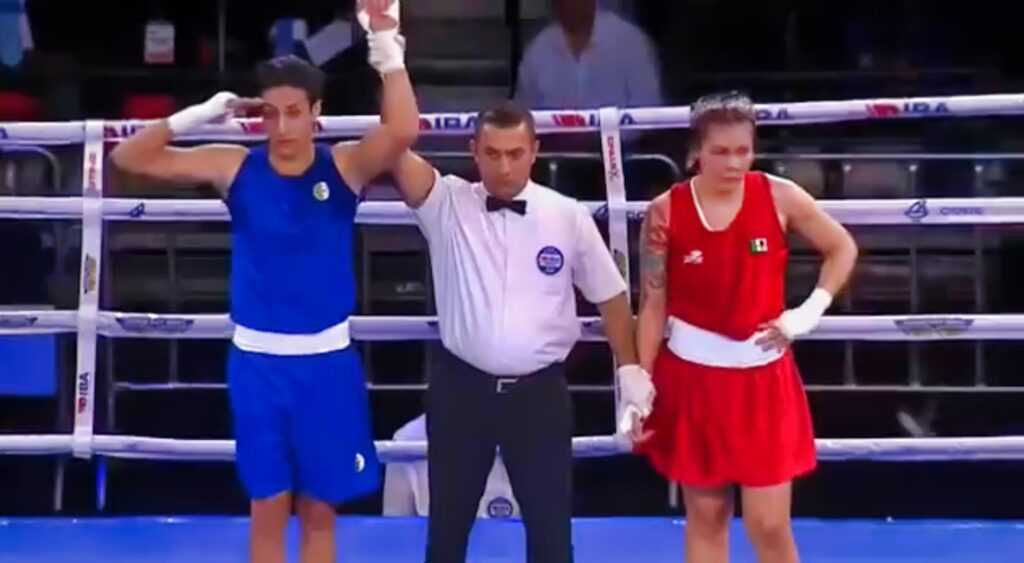 Imane Khelif raises his arm after an olympic boxing match.