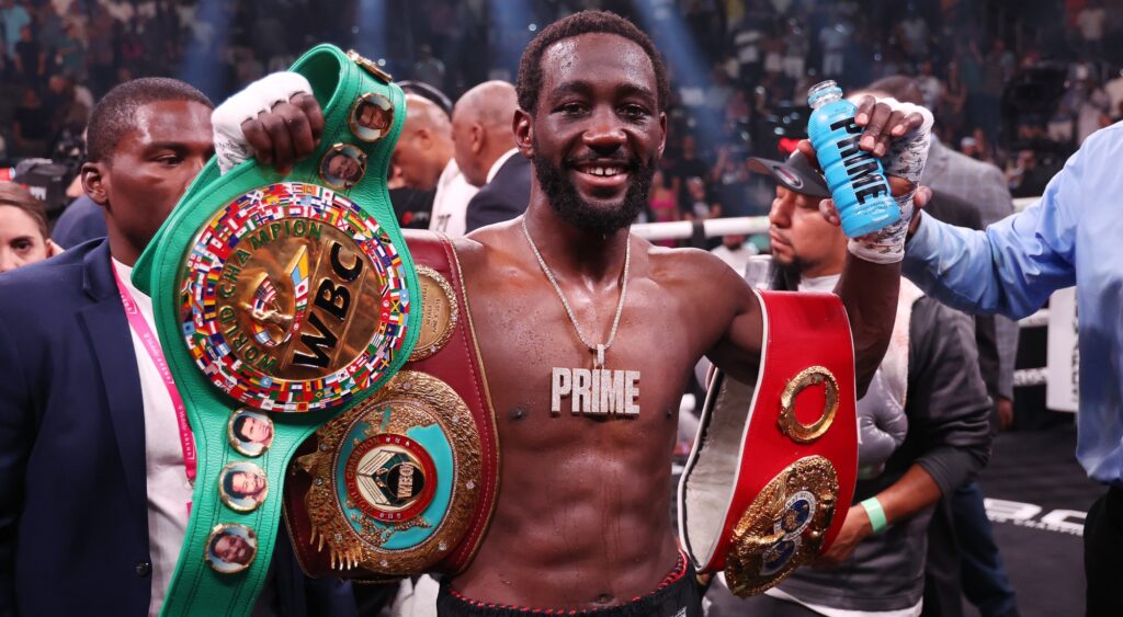 Terence Crawford celebrates with his championship belts 