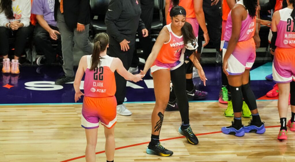 Caitlin Clark and Angel Reese slap hands during timeout at WNBA all-star game.