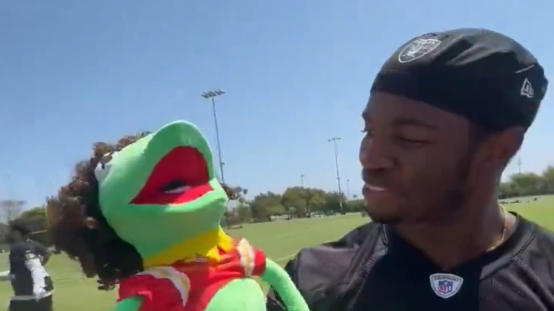 Las Vegas Raiders defensive back Trey Taylor holding up Patrick Mahomes "Kermit the Frog" puppet.