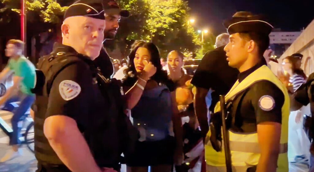 Ayesha Curry wiping her tears during confrontation with French police.