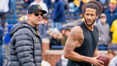 Colin Kaepernick interacts with Michigan Wolverine head coach Jim Harbaugh on field