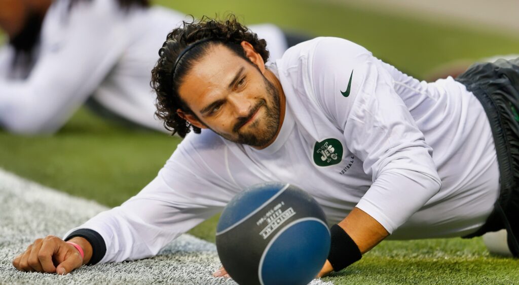 Mark Sanchez laying on the grass.