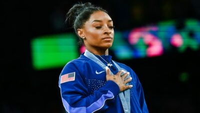 Simone Biles with her hand on her heart