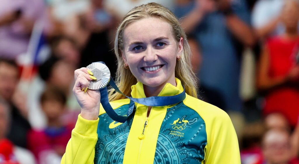 Ariarne Titmus holding up medal