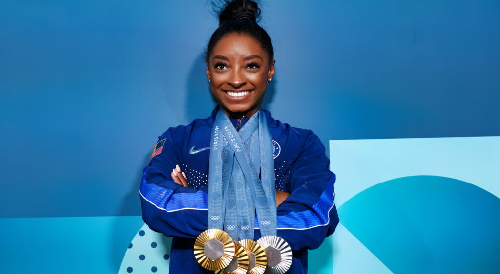 Simone Biles với bốn huy chương đeo quanh cổ