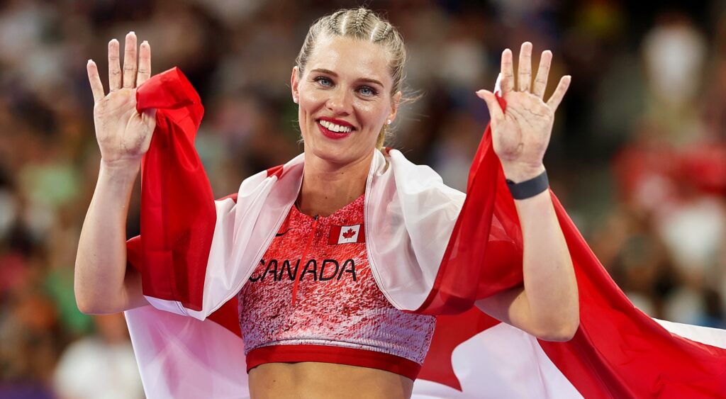 Alysha Newman covered in the Canadian flag and waving