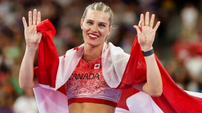 Alysha Newman covered in the Canadian flag and waving