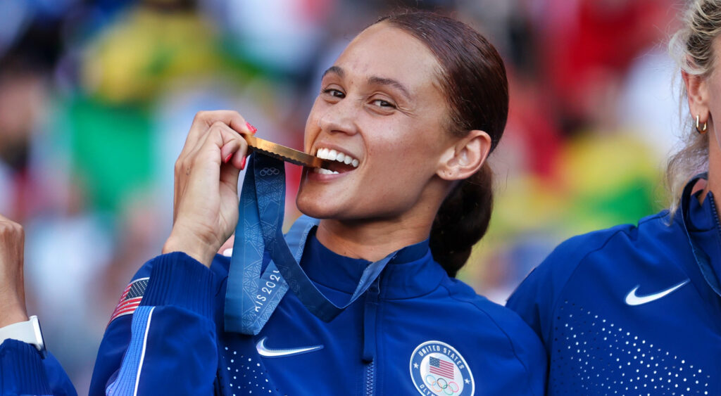 Lynn Williams biting goldd medal