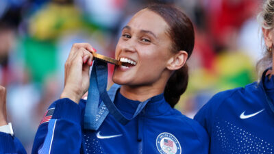 Lynn Williams biting goldd medal