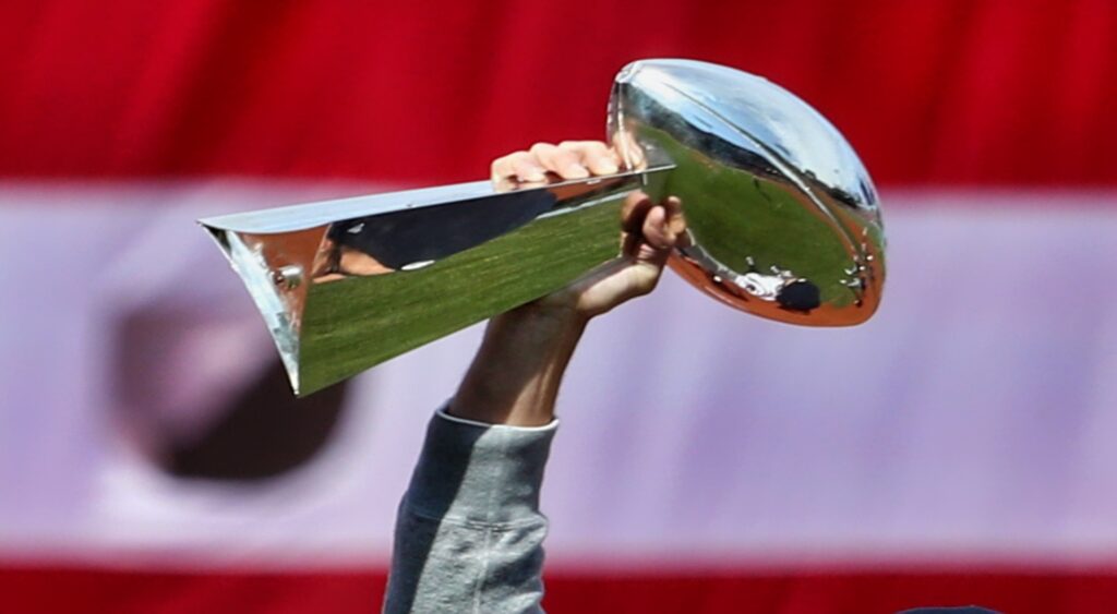 Super Bowl Trophy held in air.